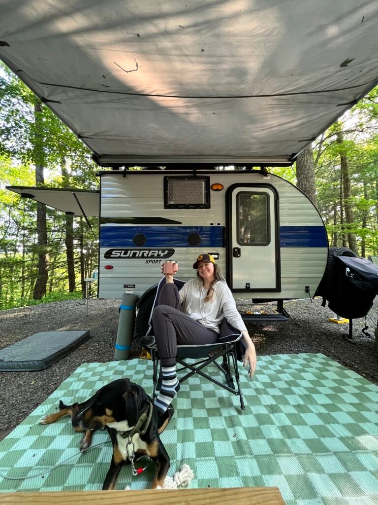 Kasey and Rocky in front of her 12ft travel trailer at a campground in Virginia